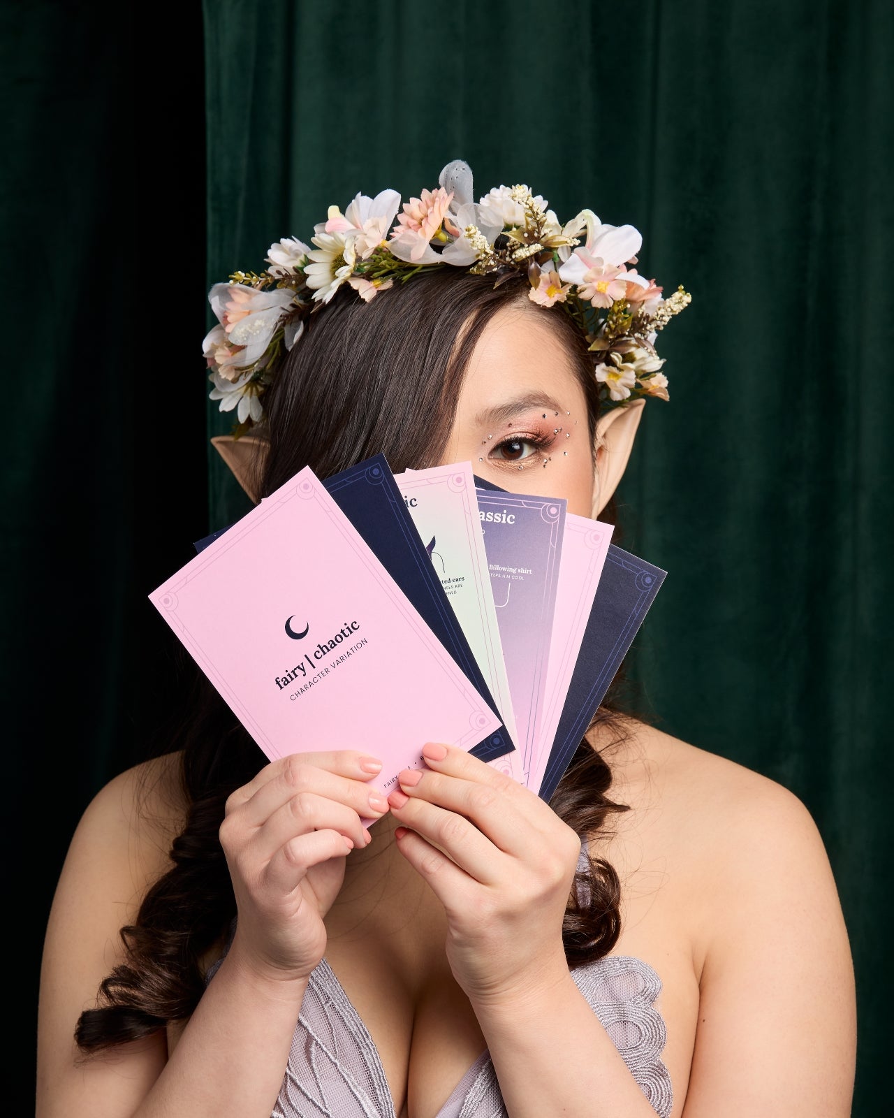 Woman wearing flower crown holding cards in front of her face
