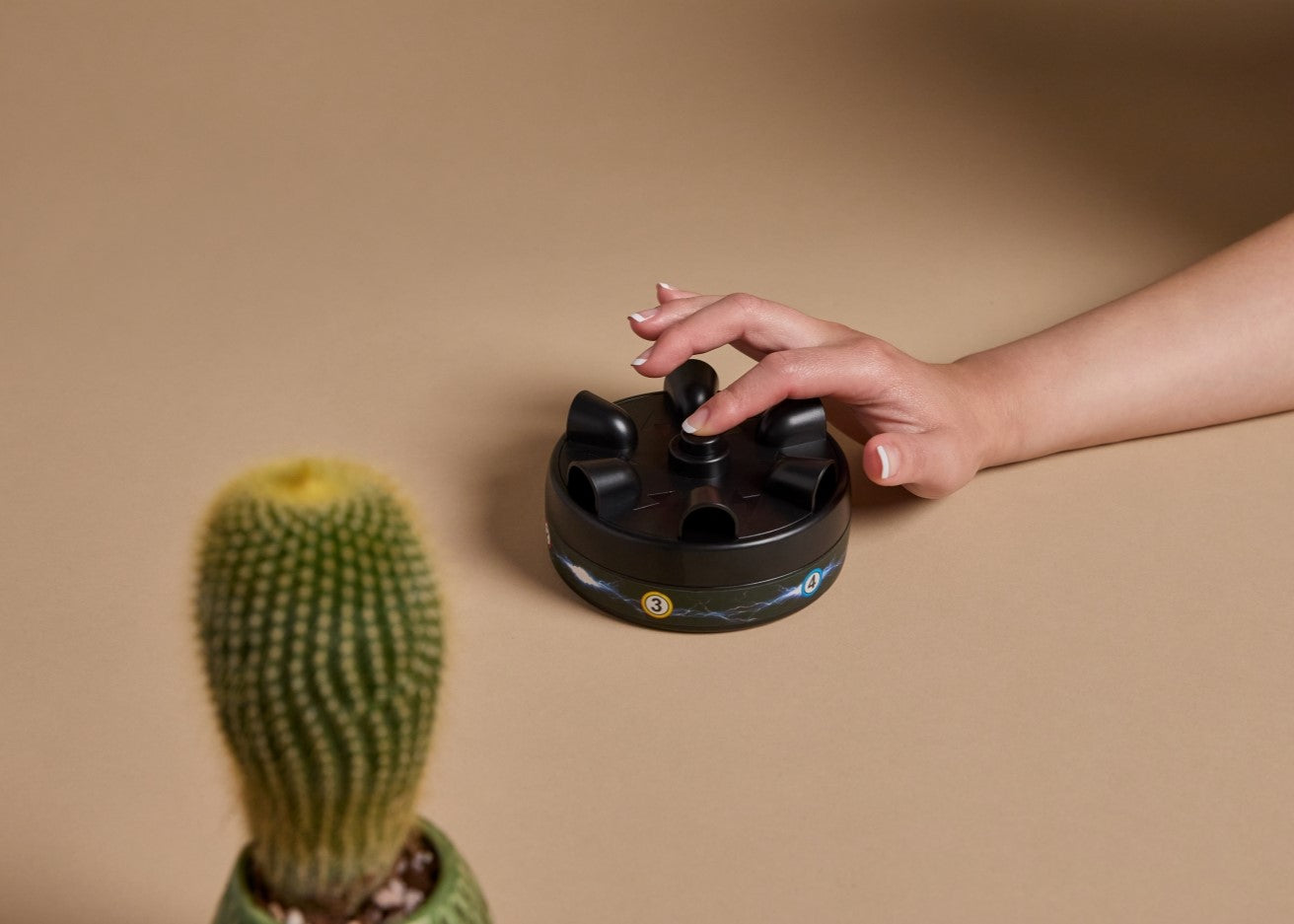 Hand pressing button on shock lie detector on brown background