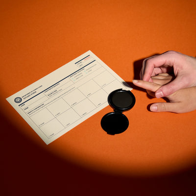 Spotlight on hand being fingerprinted with Hard Time Intake Form