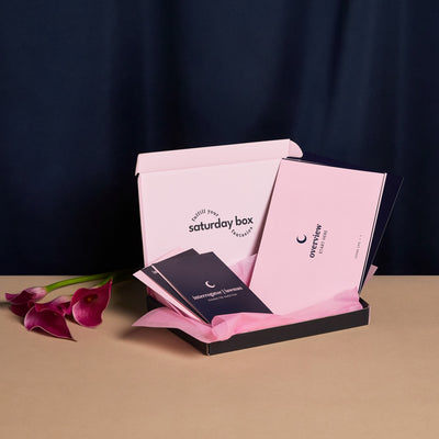 A pink box labeled 'Loose Lips Eco Box' is open revealing a few of the cards. There is a pink flower in the background.