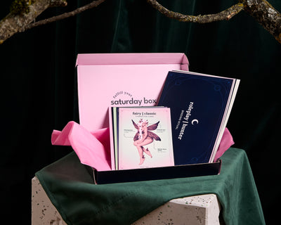 A small pink box containing cards, placed on a green background