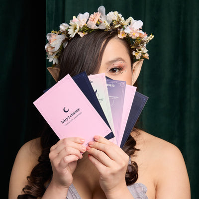 Woman in flower crown holding cards in front of her face